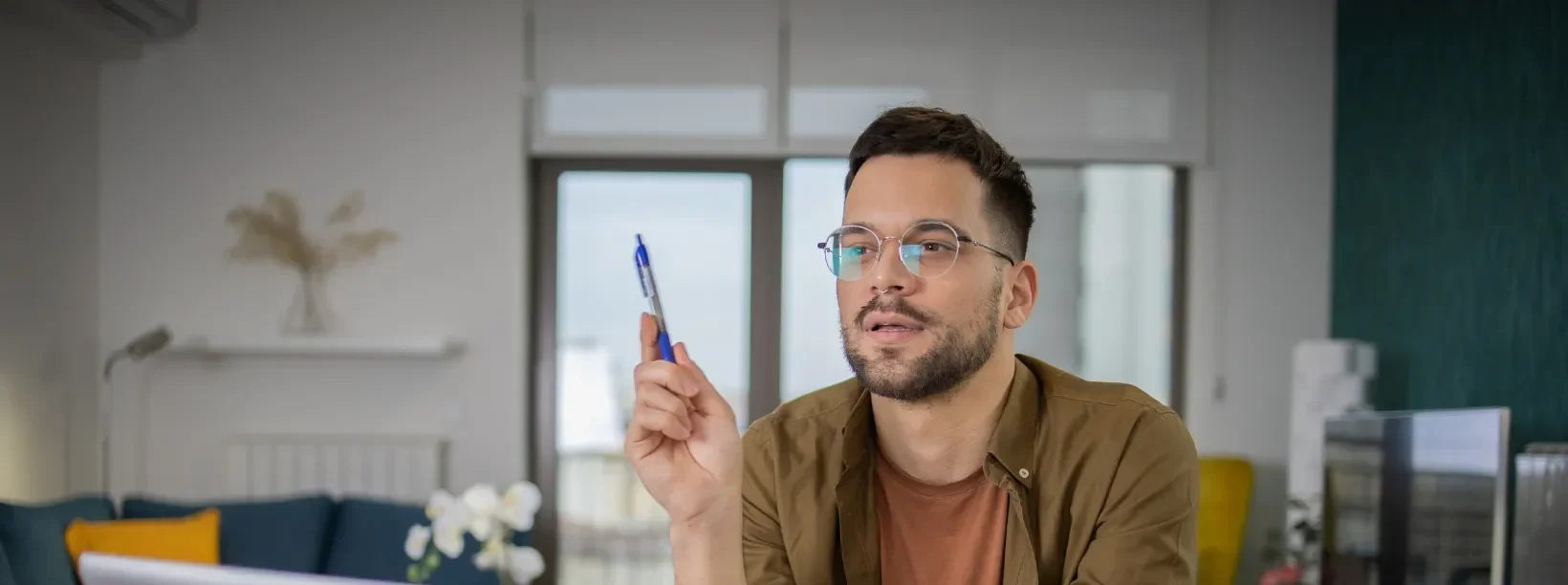 A man sitting at a desk with a pen in his hand.